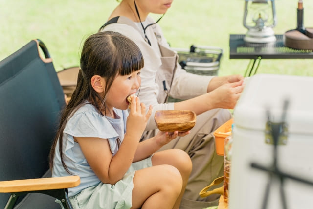 キャンプ場でごはんを食べる女の子